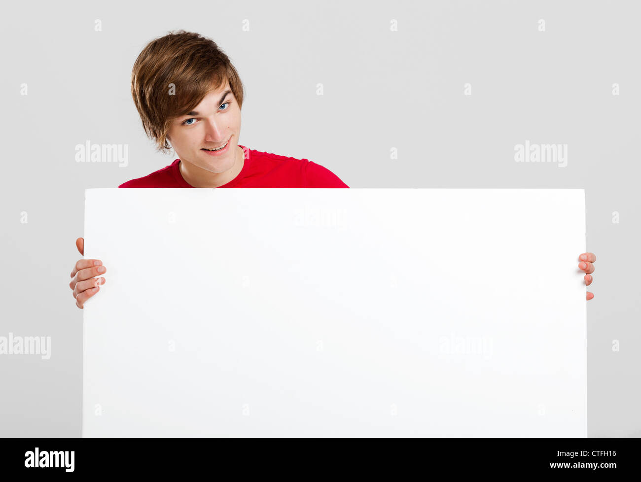 Portrait of a happy young man holding blank white card Stock Photo - Alamy