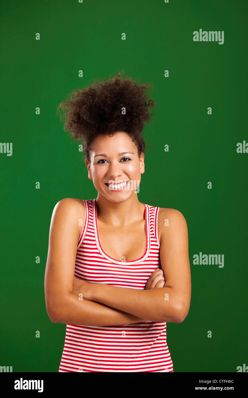 Happy African woman with hands folded over a green background Stock Photo