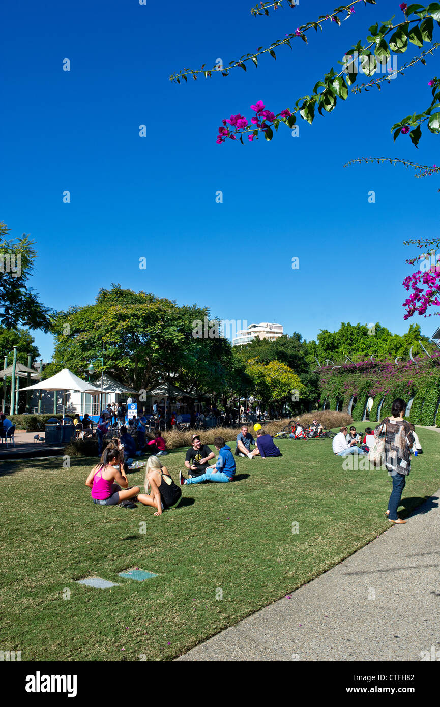 People relaxing in the sunshine on South Bank in Brisbane in Queensland in Australia. Stock Photo