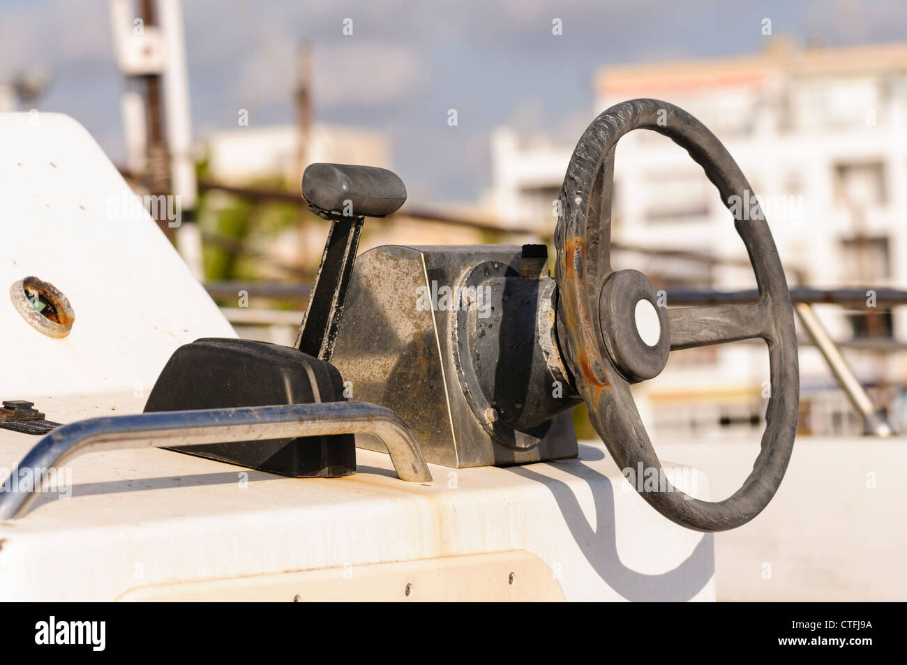 Old and worn steering wheel and throttle on a small fishing boat Stock