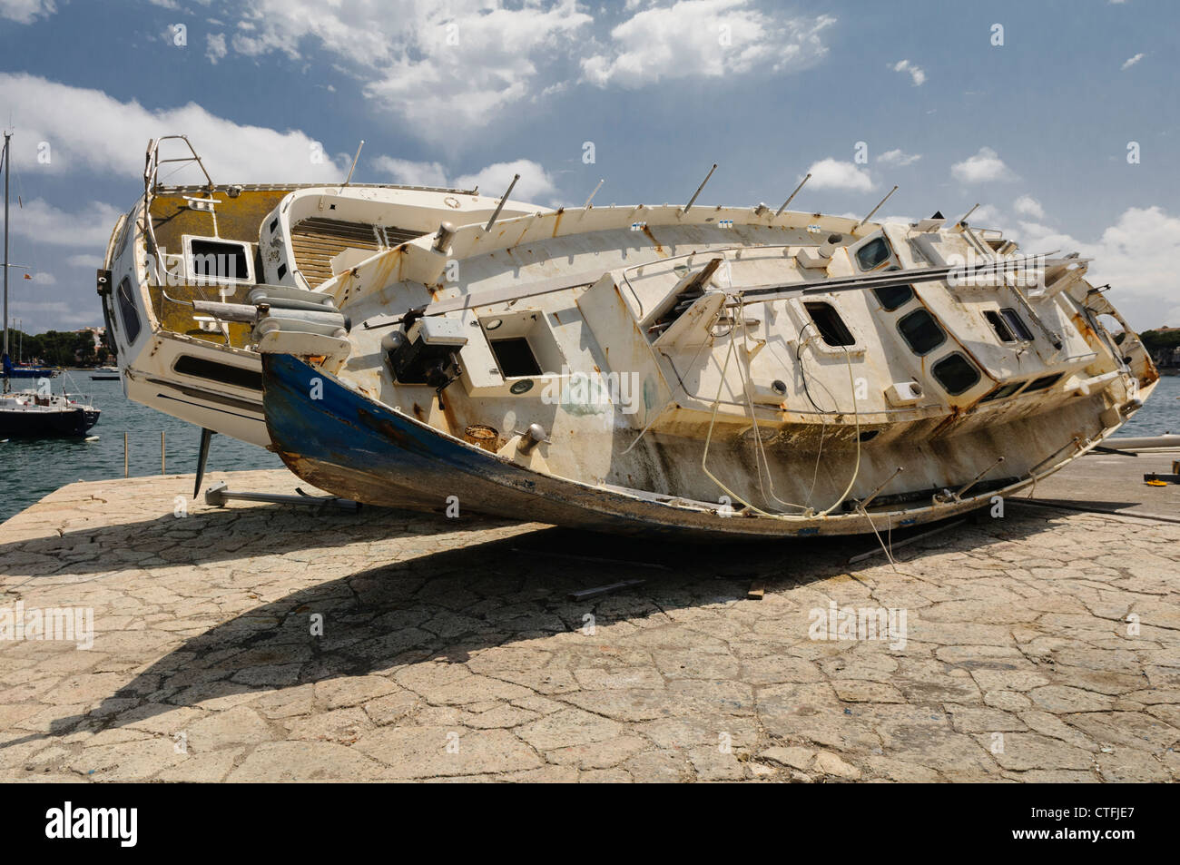 Two abandoned and derelict yachts on the end of a harbour jetty Stock