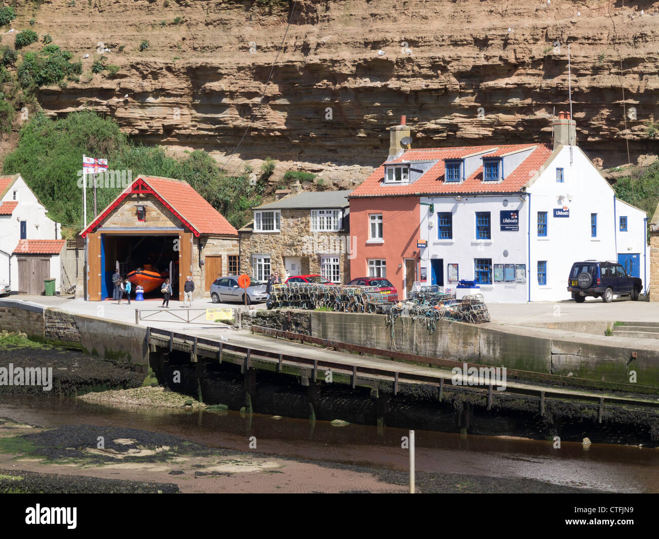 Staithes Life Boat Station Shop and slipway under the cliff at Cow Bar Nab Stock Photo