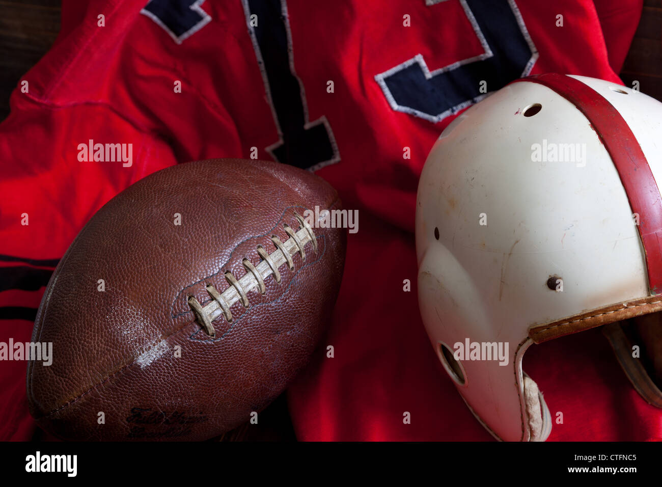 A group of vintage, antique American football equipment including a jersey, football and a helmet Stock Photo