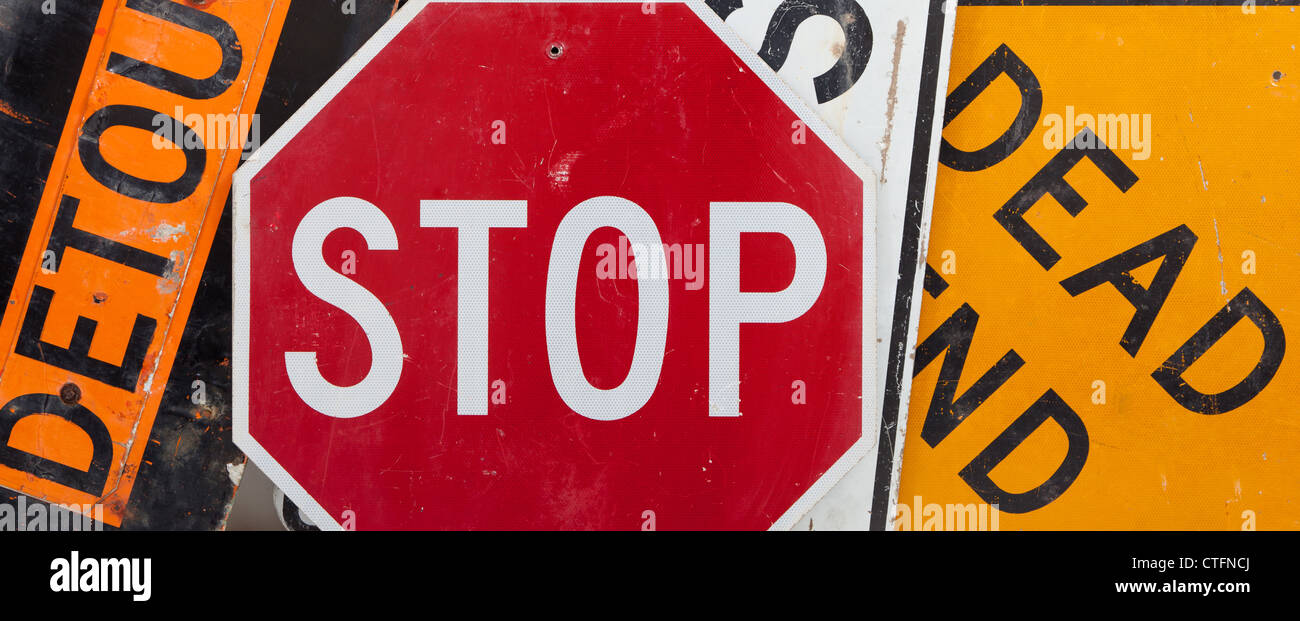 Old, vintage traffic signs including a stop sign, a detour sign, and a dead end sign making a background. Caution theme Stock Photo