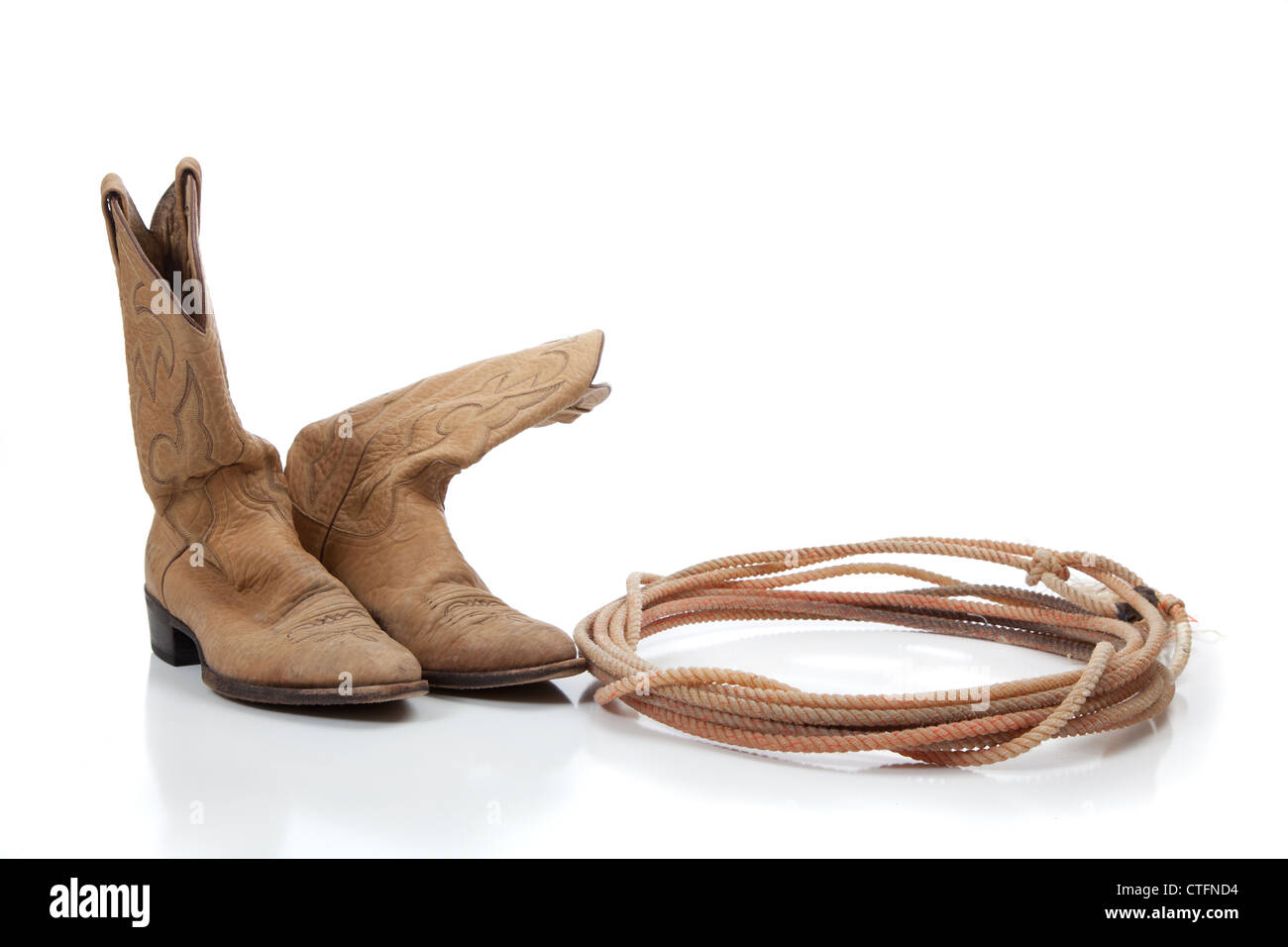 Cowboy boots and lariat rope on white with copy space Stock Photo