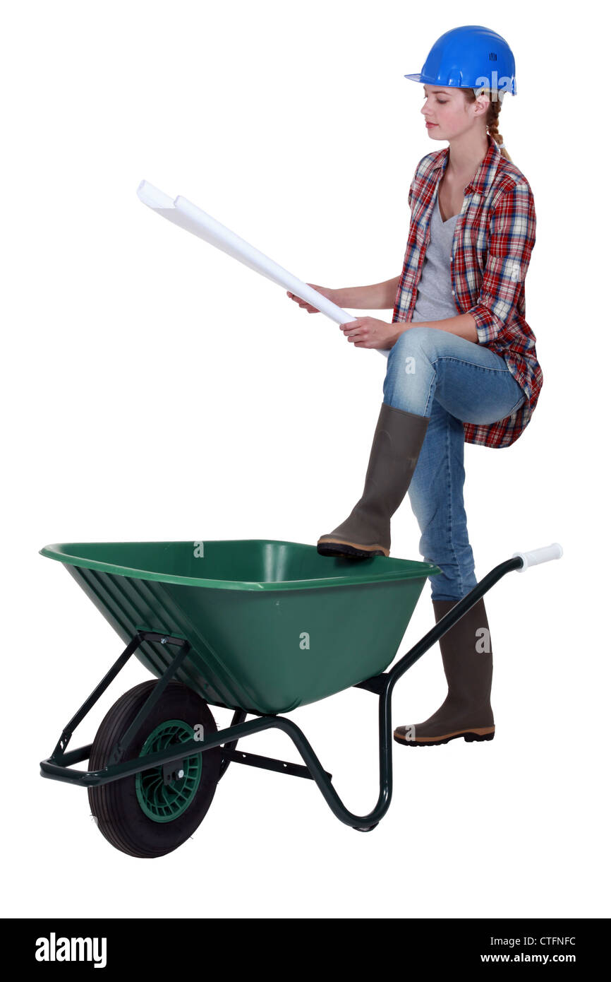 craftswoman leaning on a wheelbarrow looking at a blueprint Stock Photo ...