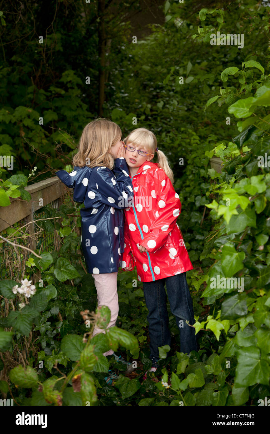 Two Young Friends Together Both Wearing Polka Dotted Raincoats Stock