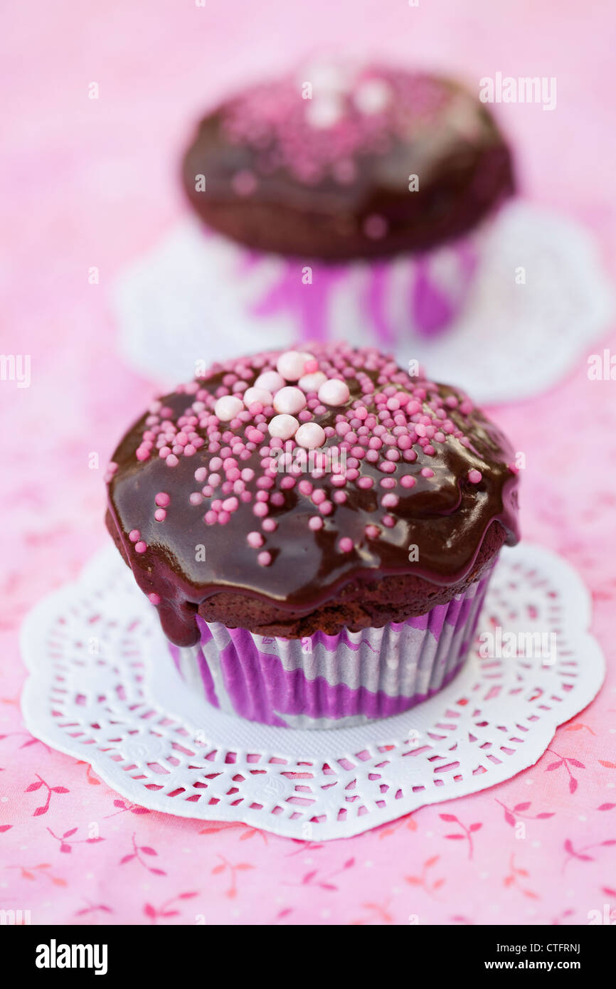 Close-up of delicious chocolate cupcakes with chocolate icing and sprinkles Stock Photo