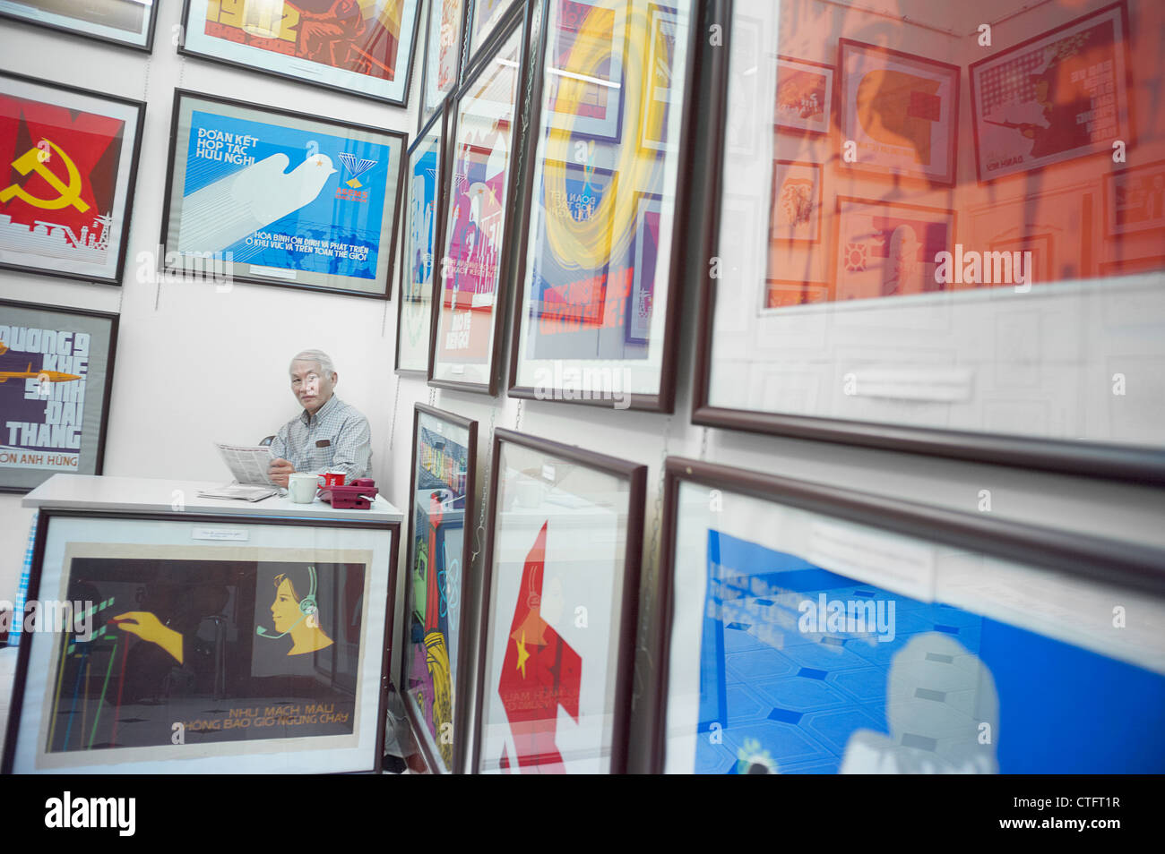 A propaganda poster shop in Vietnam with a man sitting behind a desk. Stock Photo