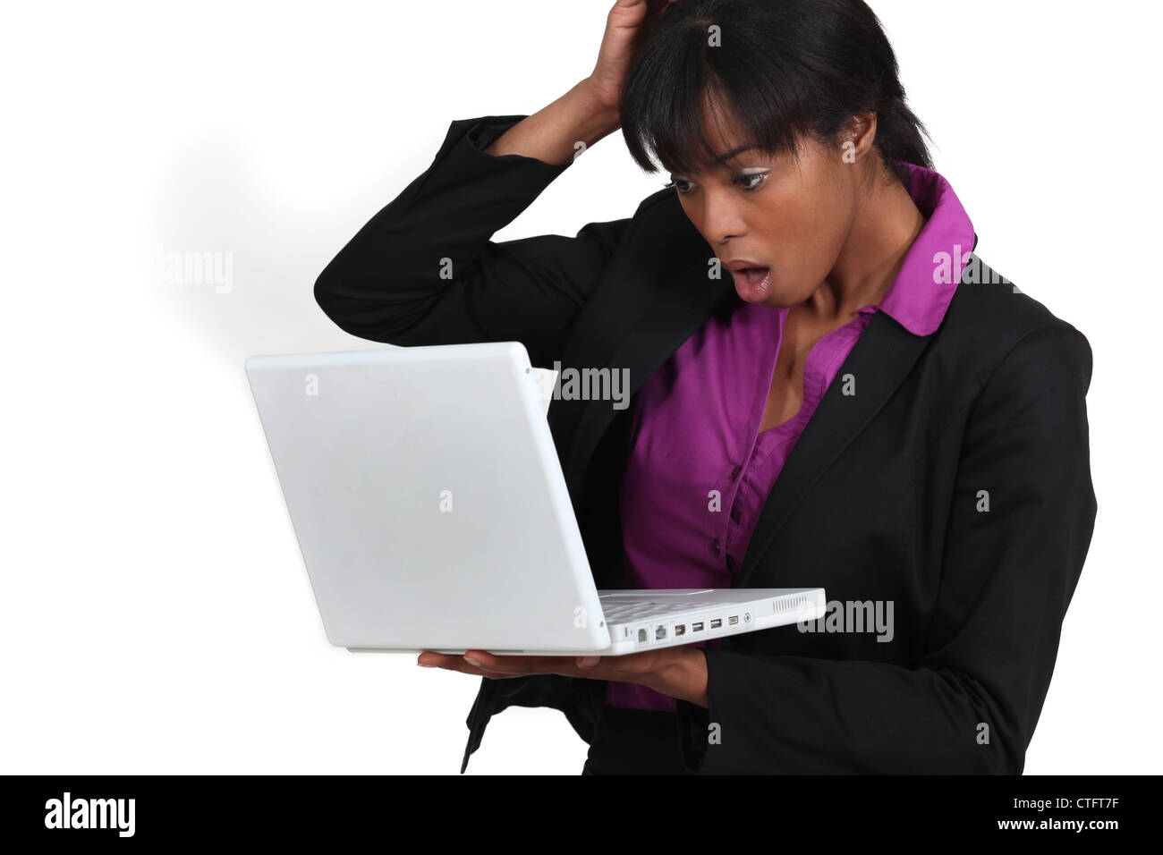 Woman looking in shock at her laptop Stock Photo - Alamy