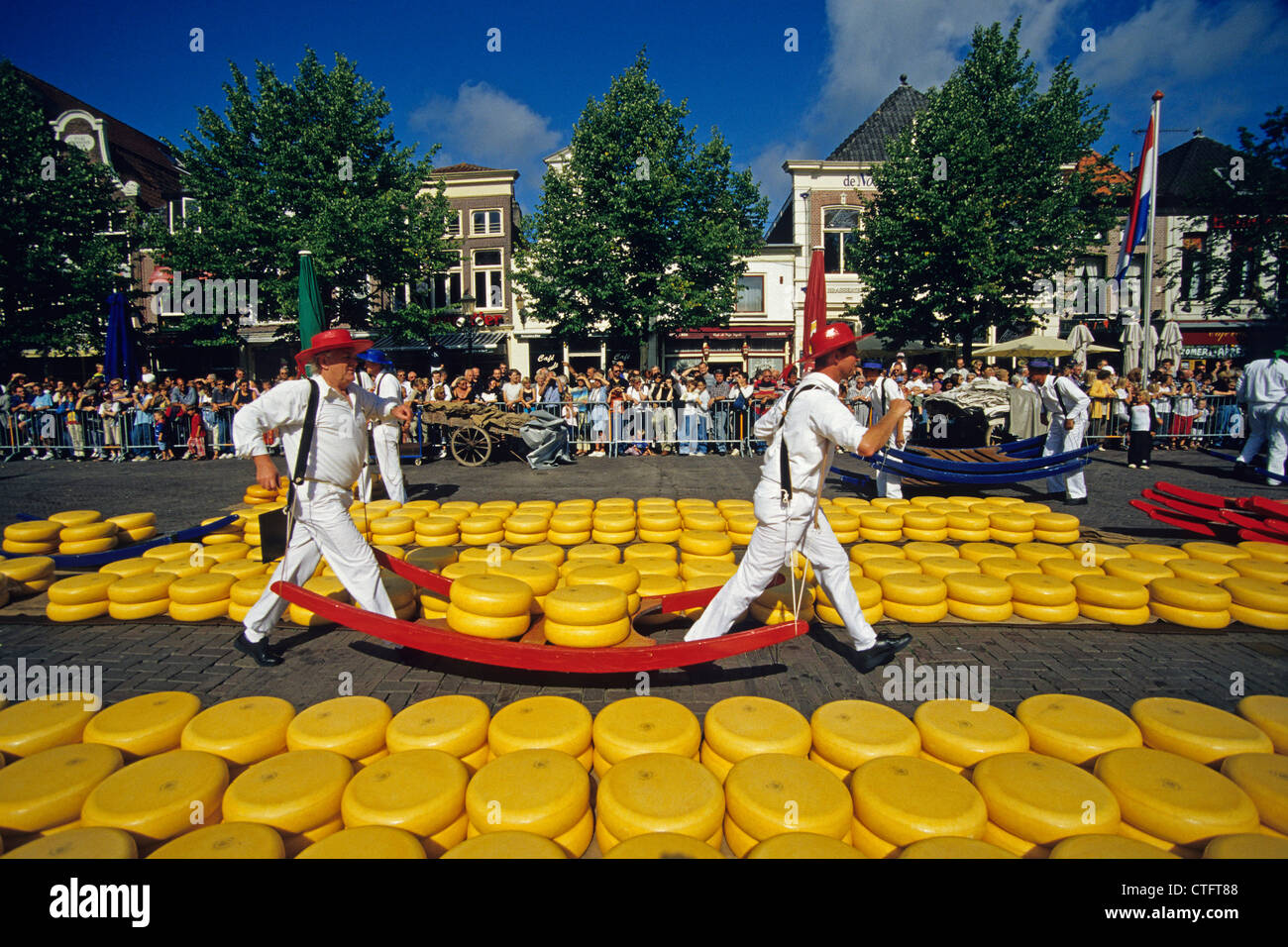 Netherlands, Alkmaar, Men in traditional clothing carrying cheese. Stock Photo