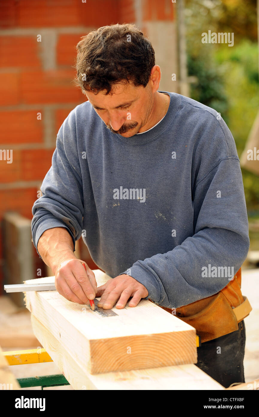 Carpenter marking wood with pencil Stock Photo Alamy