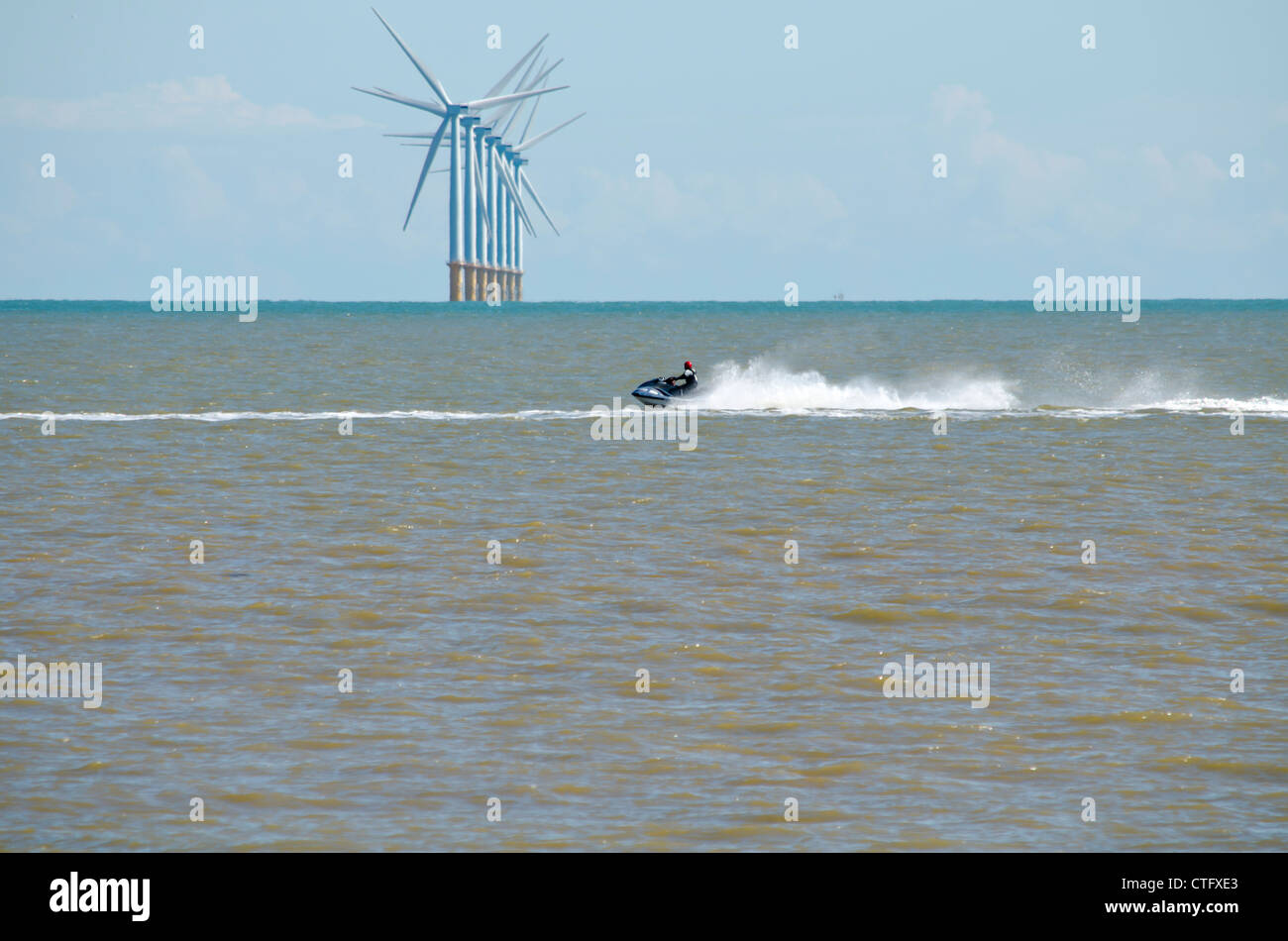 Jet ski going pasted a wind farm Stock Photo