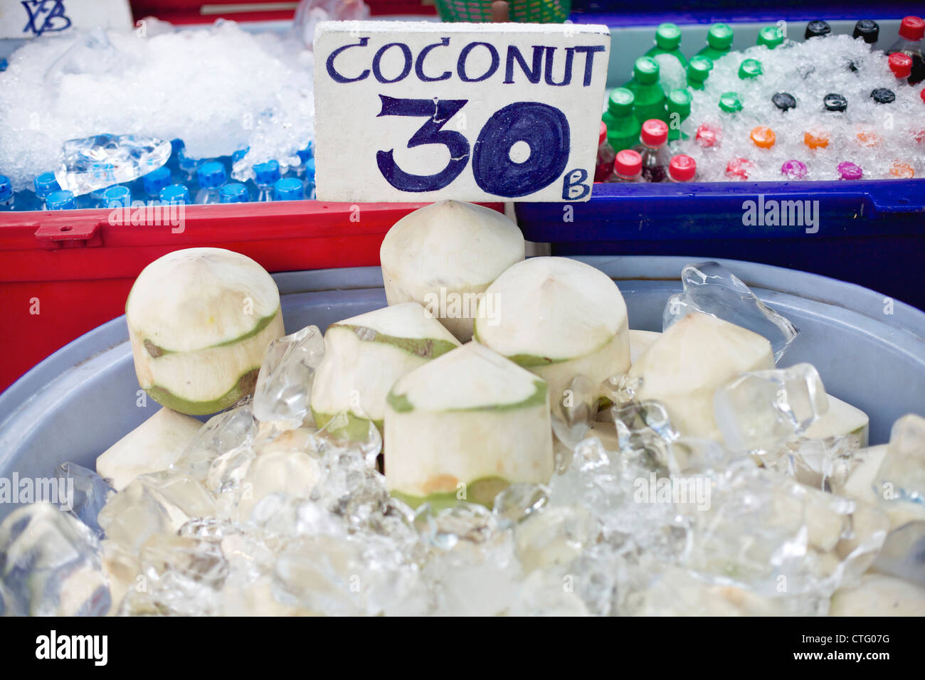 Fresh coconuts on ice in Tahiland with 30 Baht sign Stock Photo
