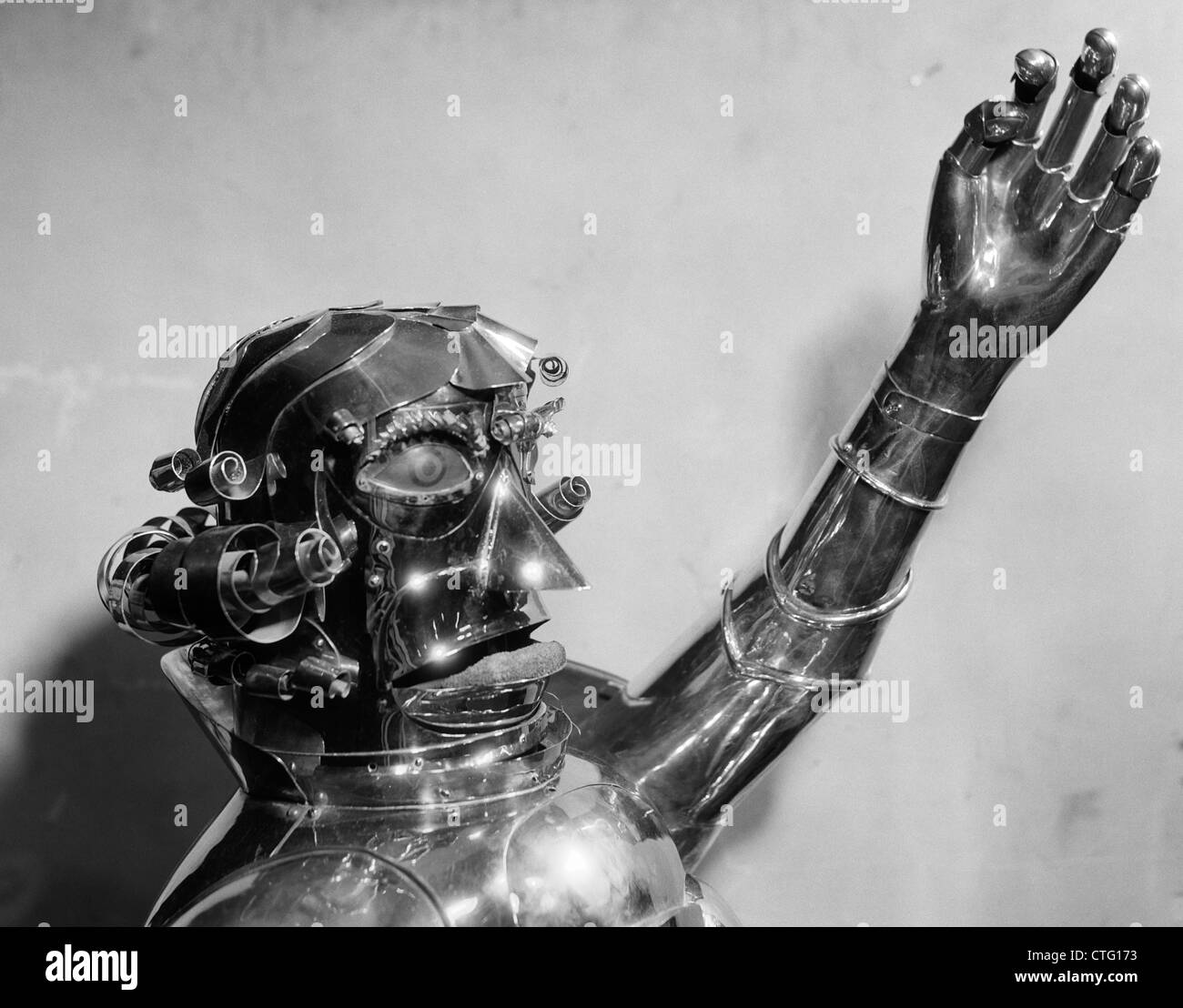 1930s 1940s METAL ROBOT HEAD AND CHEST WITH ONE ARM RAISED AND MOUTH IN A SCOWL Stock Photo