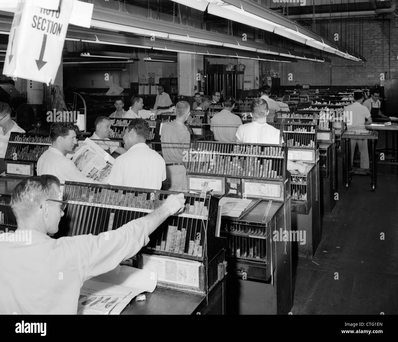 1950S MEN WORKING IN NEWSPAPER ADVERTISEMENT COMPOSING ROOM SETTING AD TYPE Stock Photo