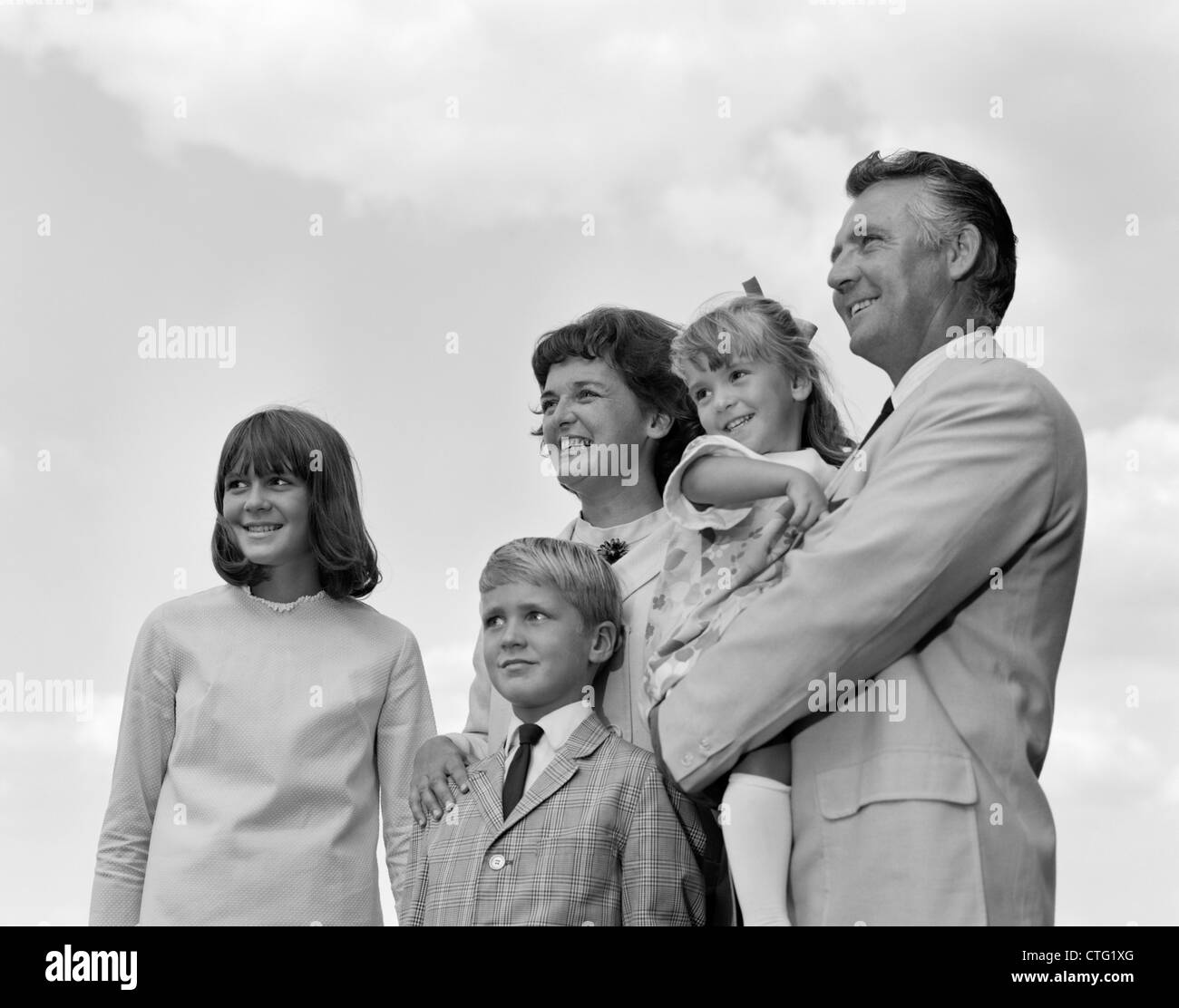 1960s PORTRAIT FAMILY OF FIVE OUTSIDE LOOKING OFF INTO DISTANCE Stock Photo