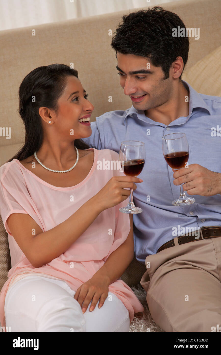 Relaxed young couple holding wineglass together at home Stock Photo