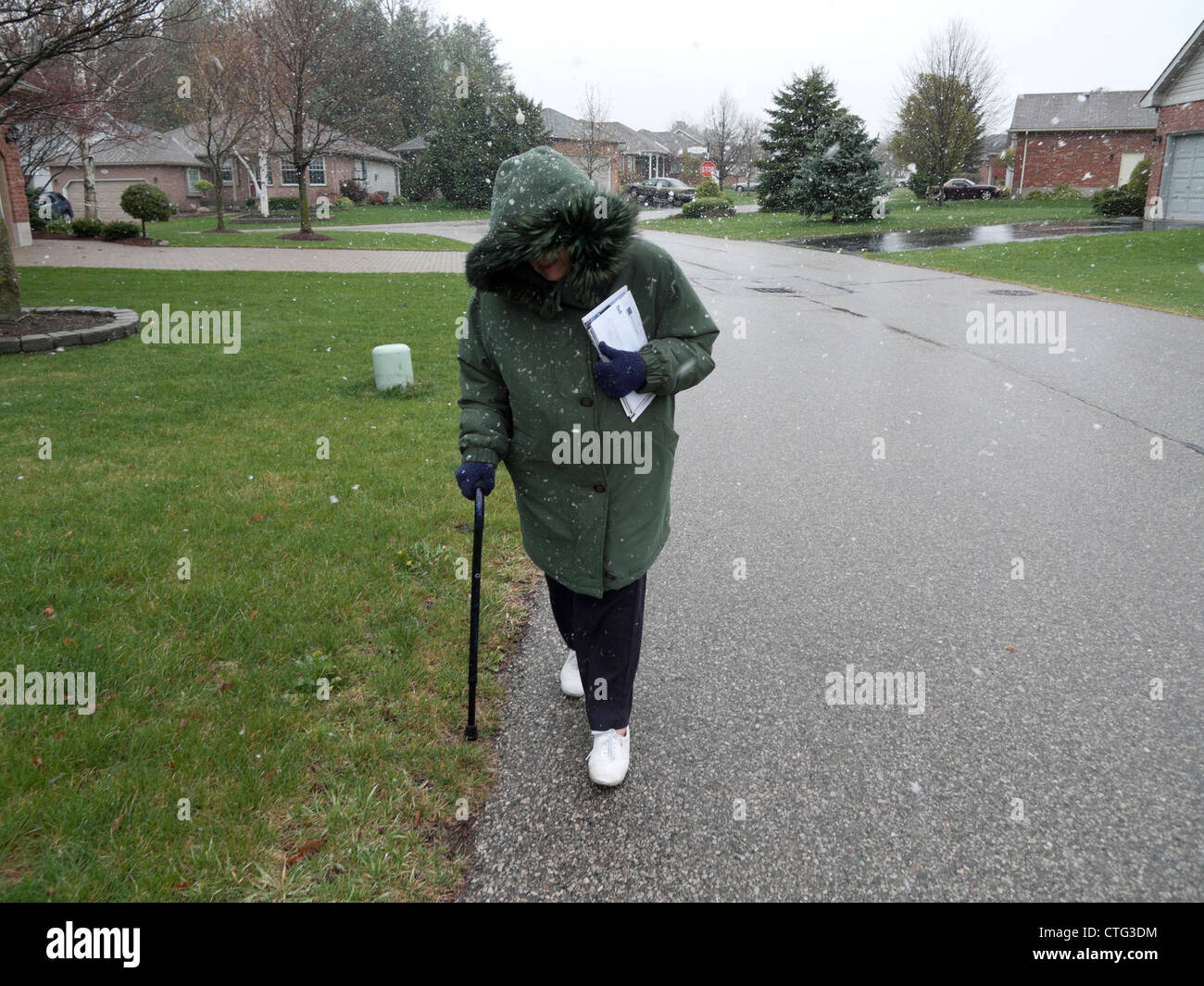 An elderly pensioner in her walking in cold windy weather