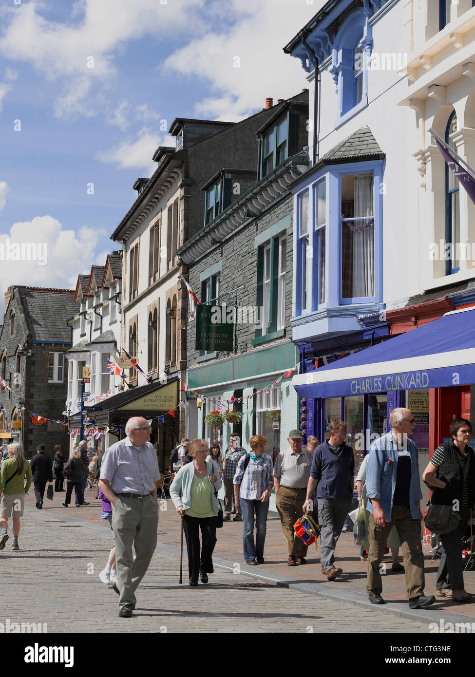 People tourists visitors walking by shops stores along Market Square in
