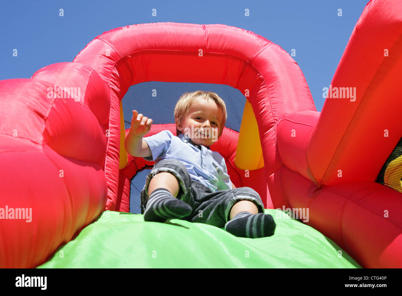 Child on inflatable bouncy castle slide Stock Photo