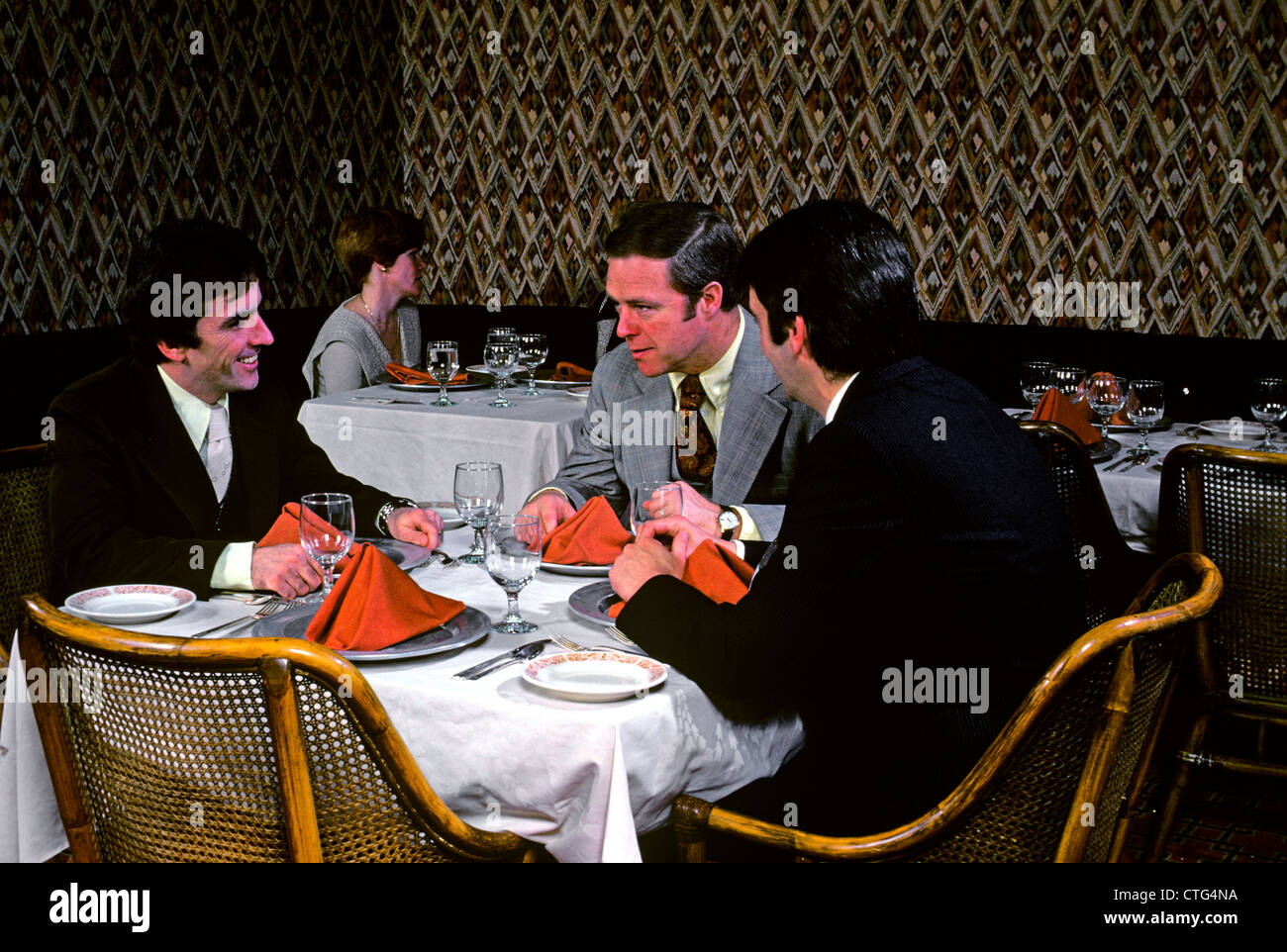 1970s 3 BUSINESSMEN AT TABLE IN RESTAURANT Stock Photo