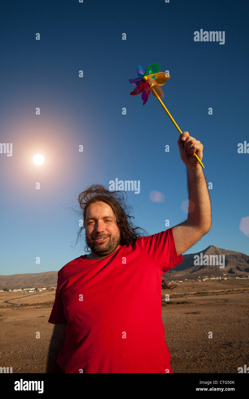 Man in red shirt with wind wheel in the hand Stock Photo