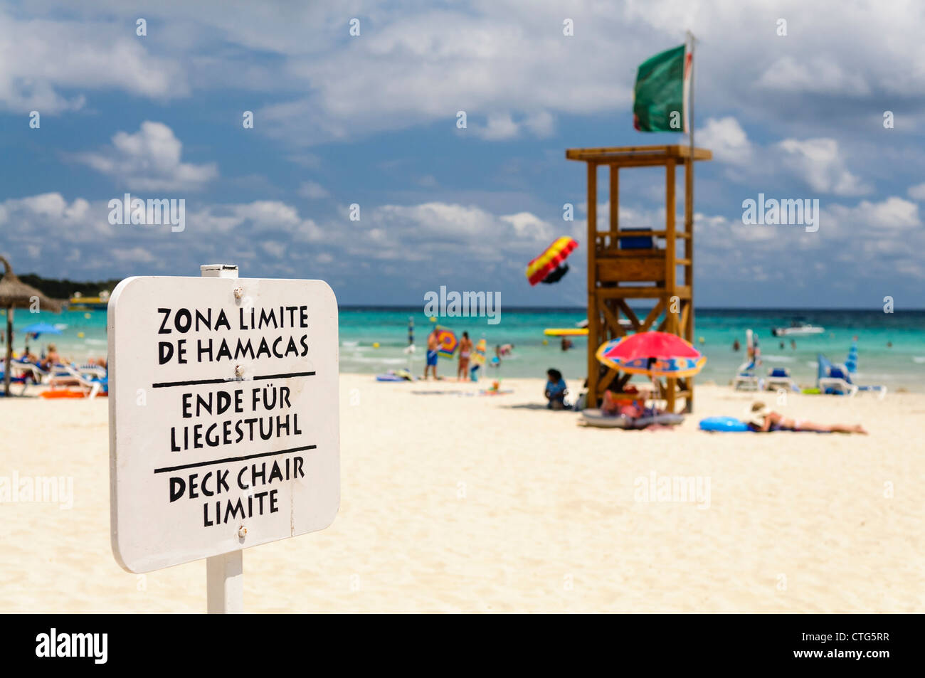 Multilingual sign on a beach indicating the limit for deck chairs Stock ...