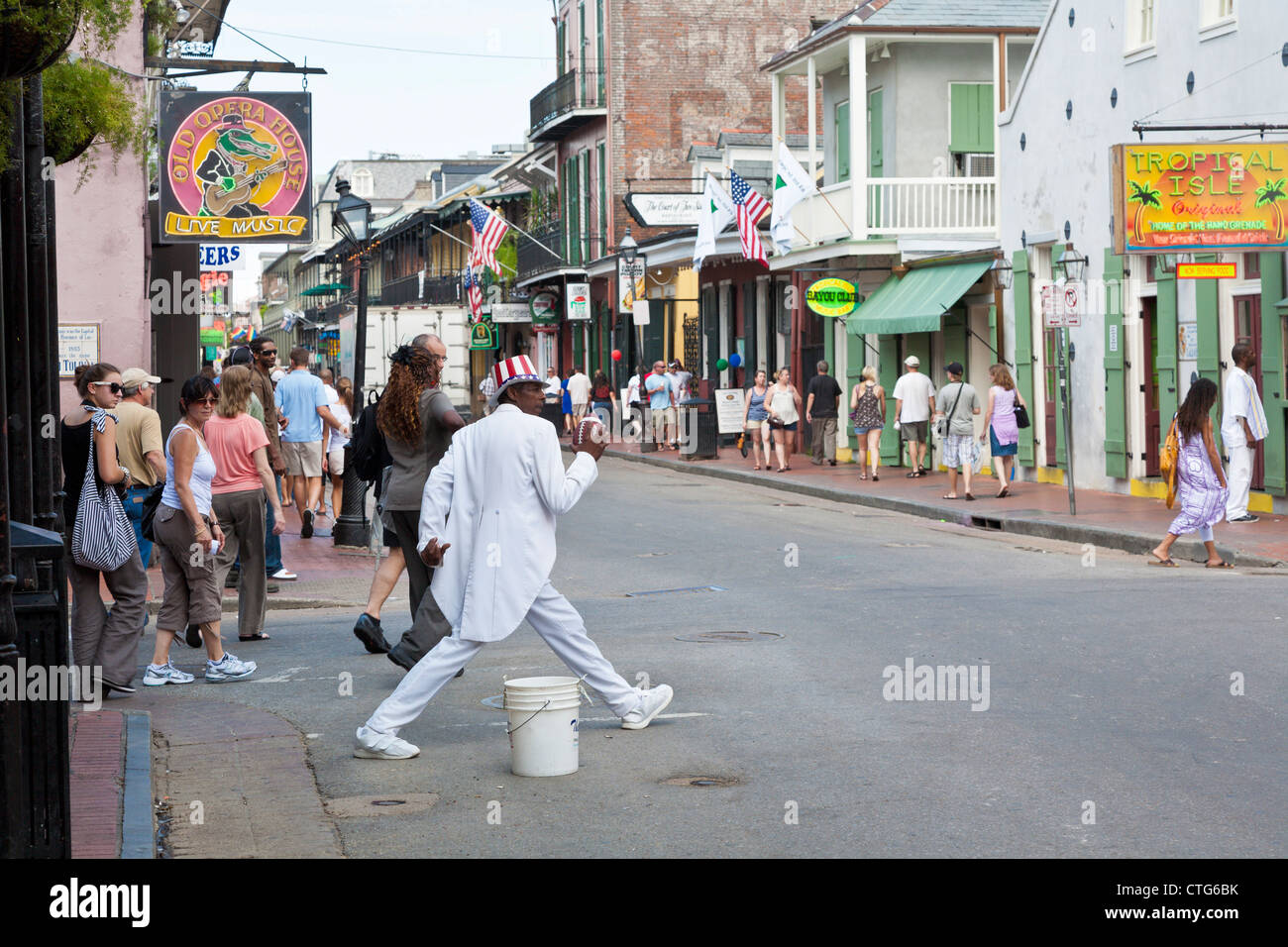 Black street performer in white tuxedo with football on Bourbon Street in the French Quarter of New Orleans, LA Stock Photo