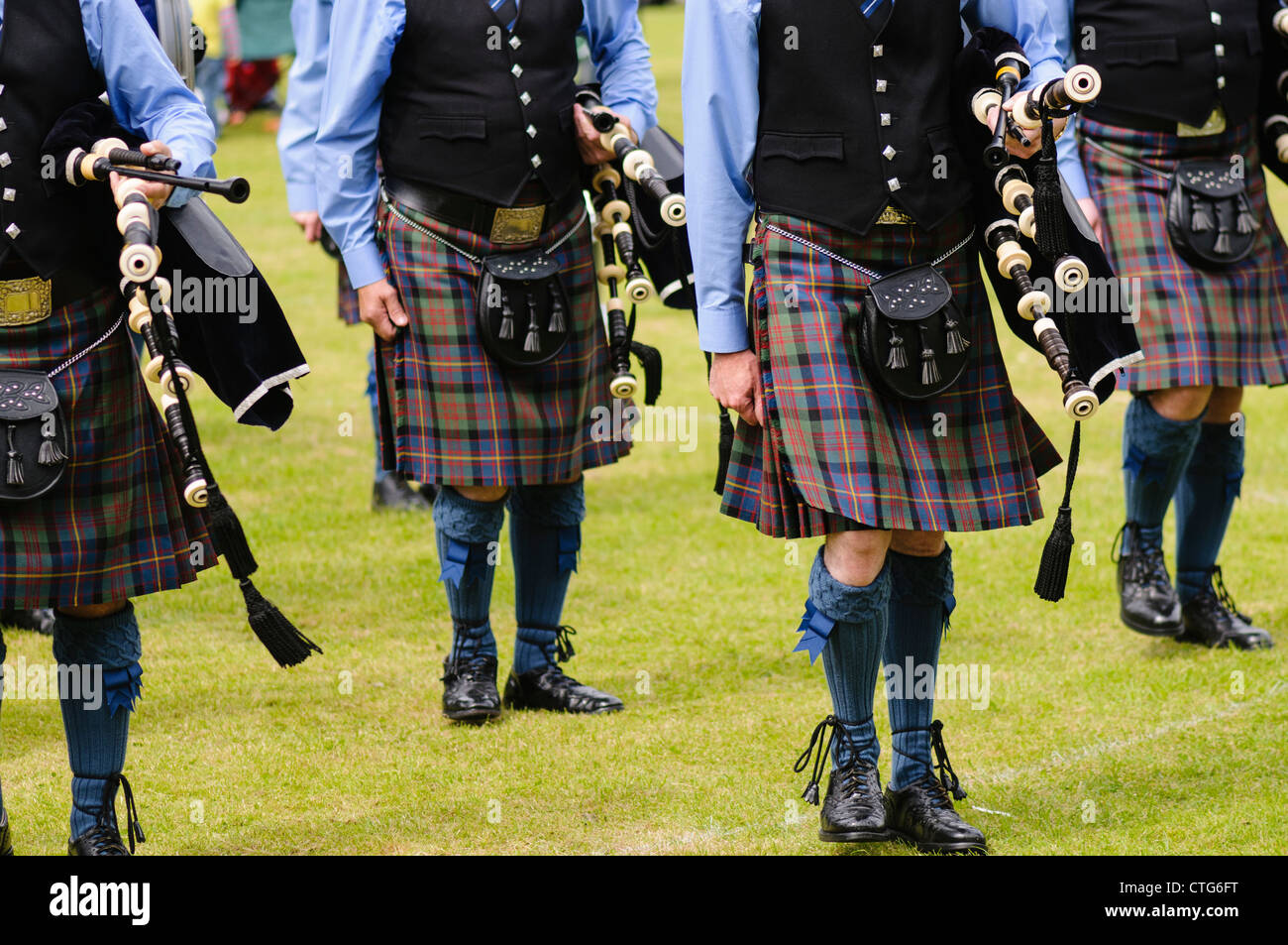 Bagpipers wearing kilts marching while carrying their bagpipes Stock