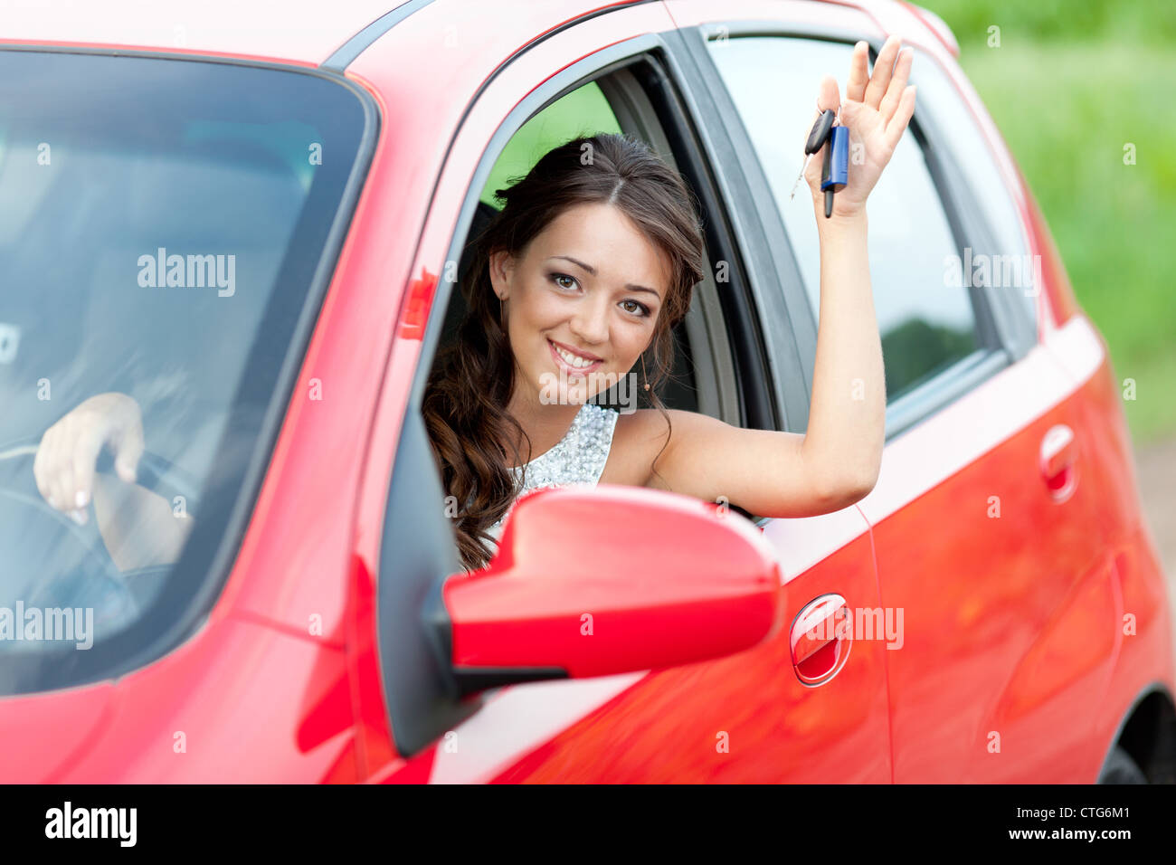 Happy woman in red car holding keys and smiling Stock Photo - Alamy