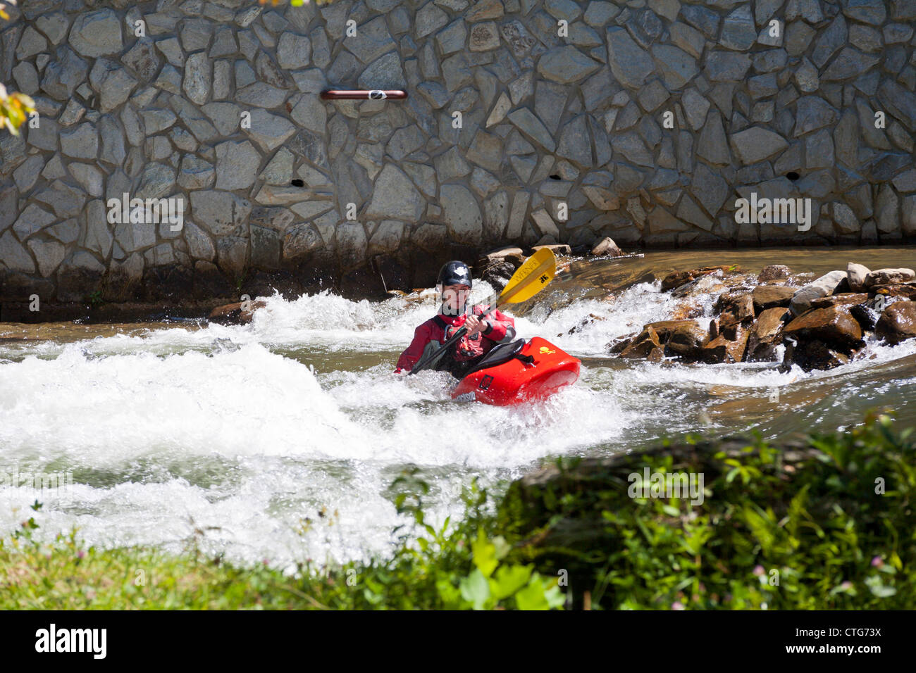 Whitewater kayaker maneuvering kayak in rapids at the Nantahala Outdoor Center in North Carolina Stock Photo