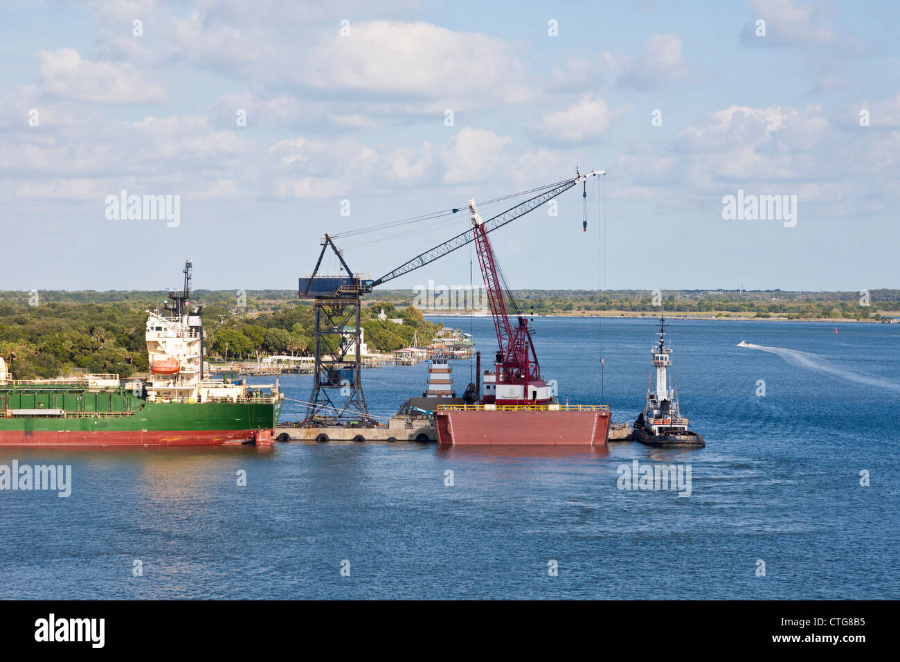 Bitu Mountain, tug boats and a crane barge docked in the St. Johns River In Jacksonville, Florida, USA Stock Photo