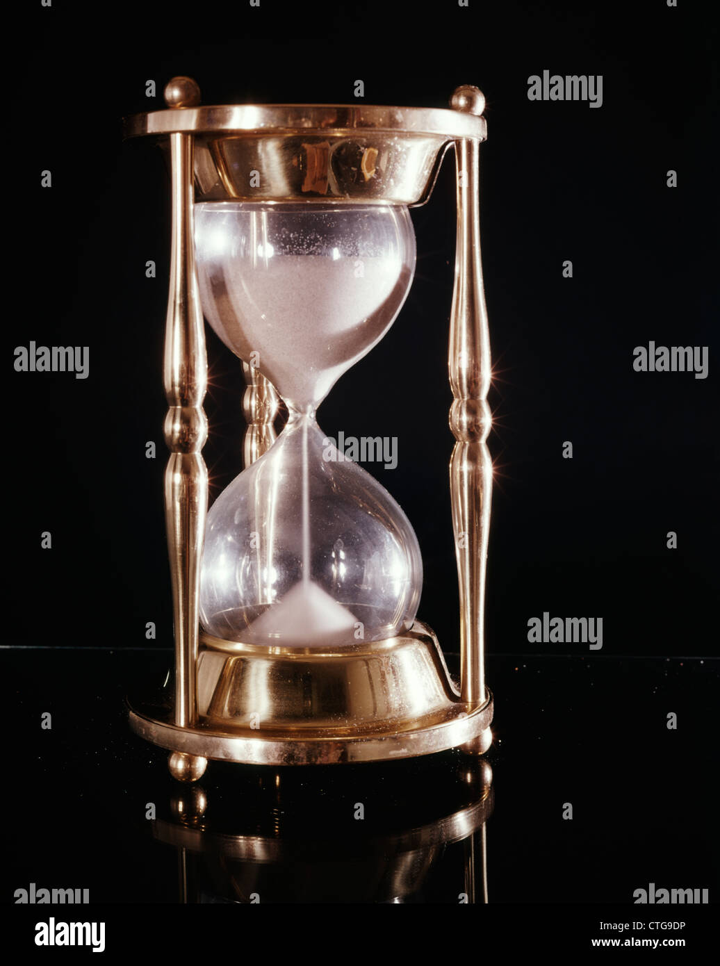 BRASS HOURGLASS BLACK BACKGROUND Stock Photo