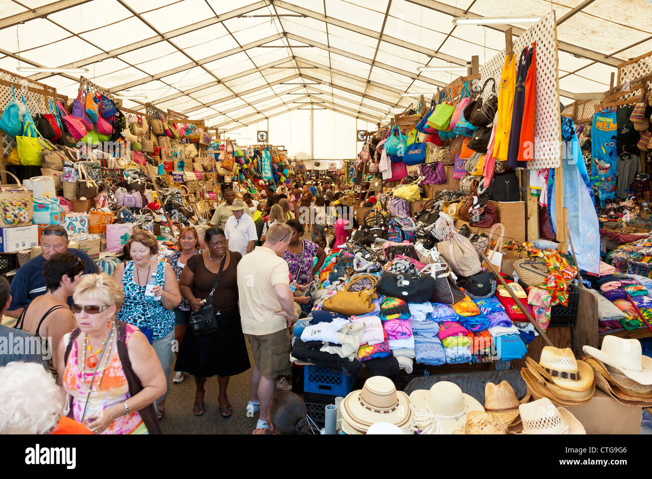 Men and women tourists shop in the crowded Straw Market for gifts and