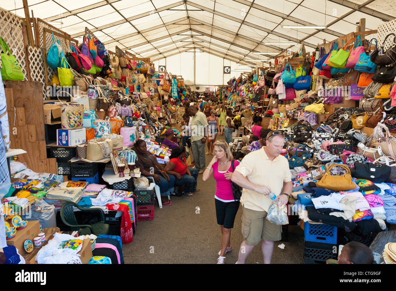 Men and women tourists shop in the crowded Straw Market for gifts and