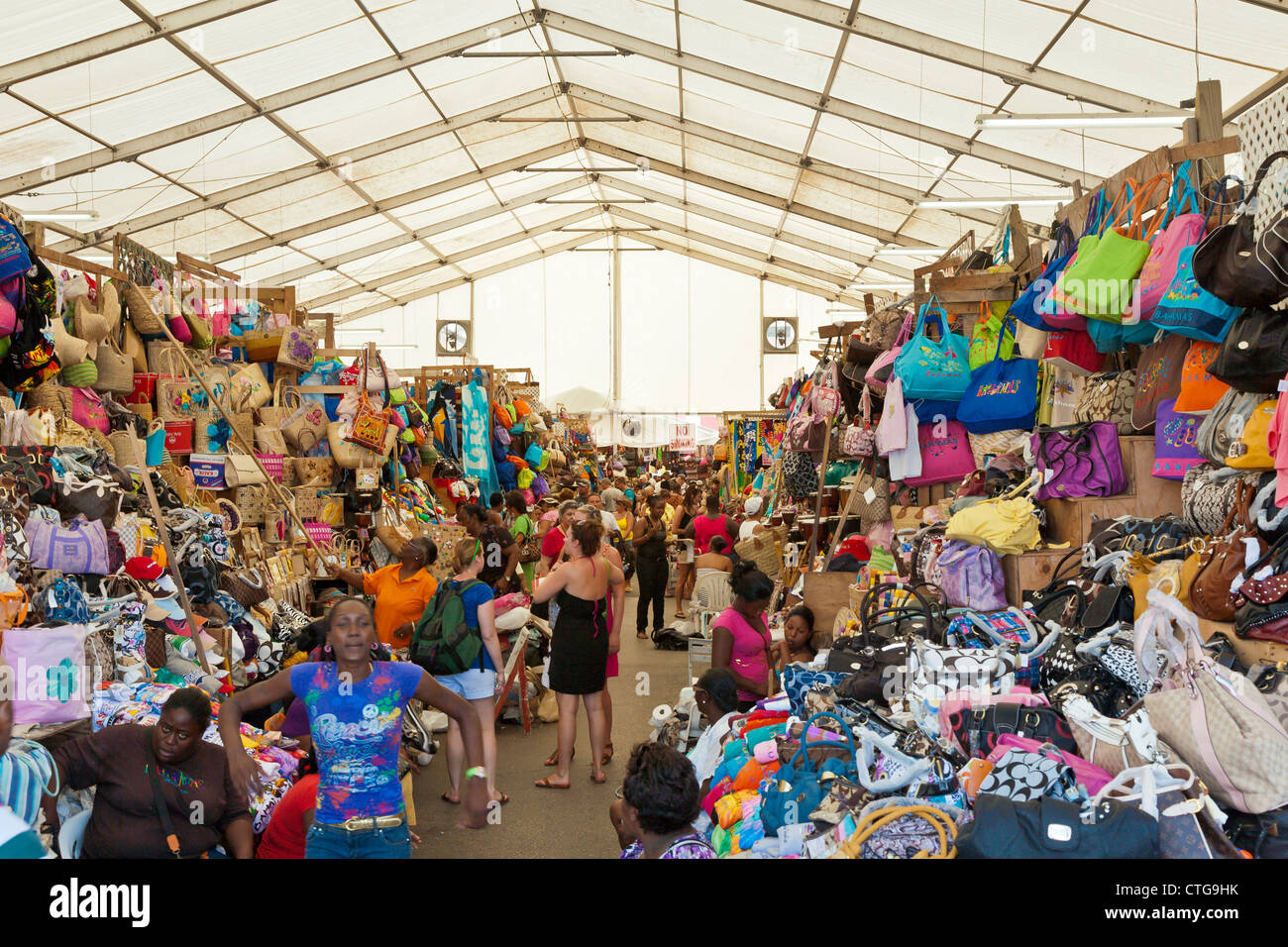 Men and women tourists shop in the crowded Straw Market for gifts and