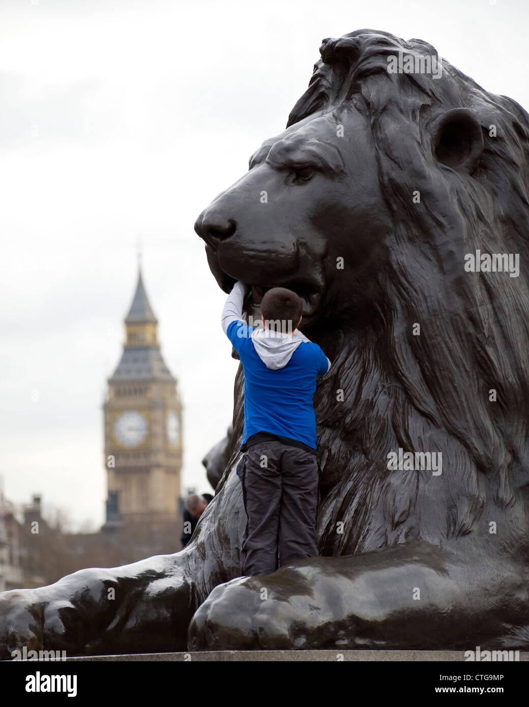 Boy climbing on a Landseer Lion in Trafalgar Square Stock Photo