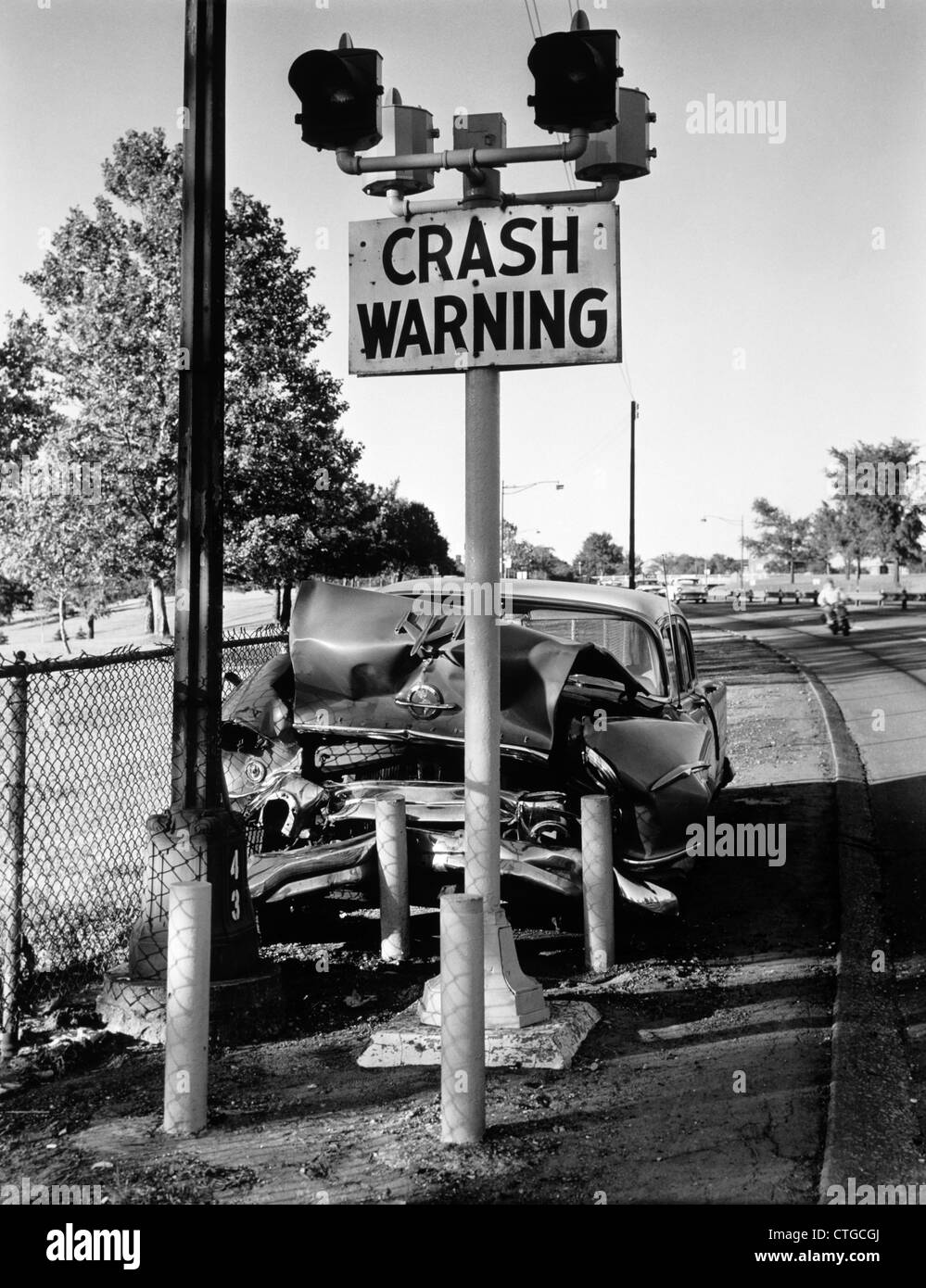 1960s 1950s CAR CRASHED HEAD-ON INTO CRASH WARNING SIGN POLE SYMBOLIC OUTDOOR Stock Photo