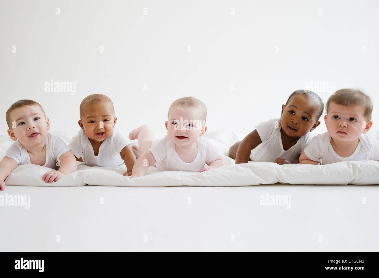 Babies laying on floor together Stock Photo Alamy