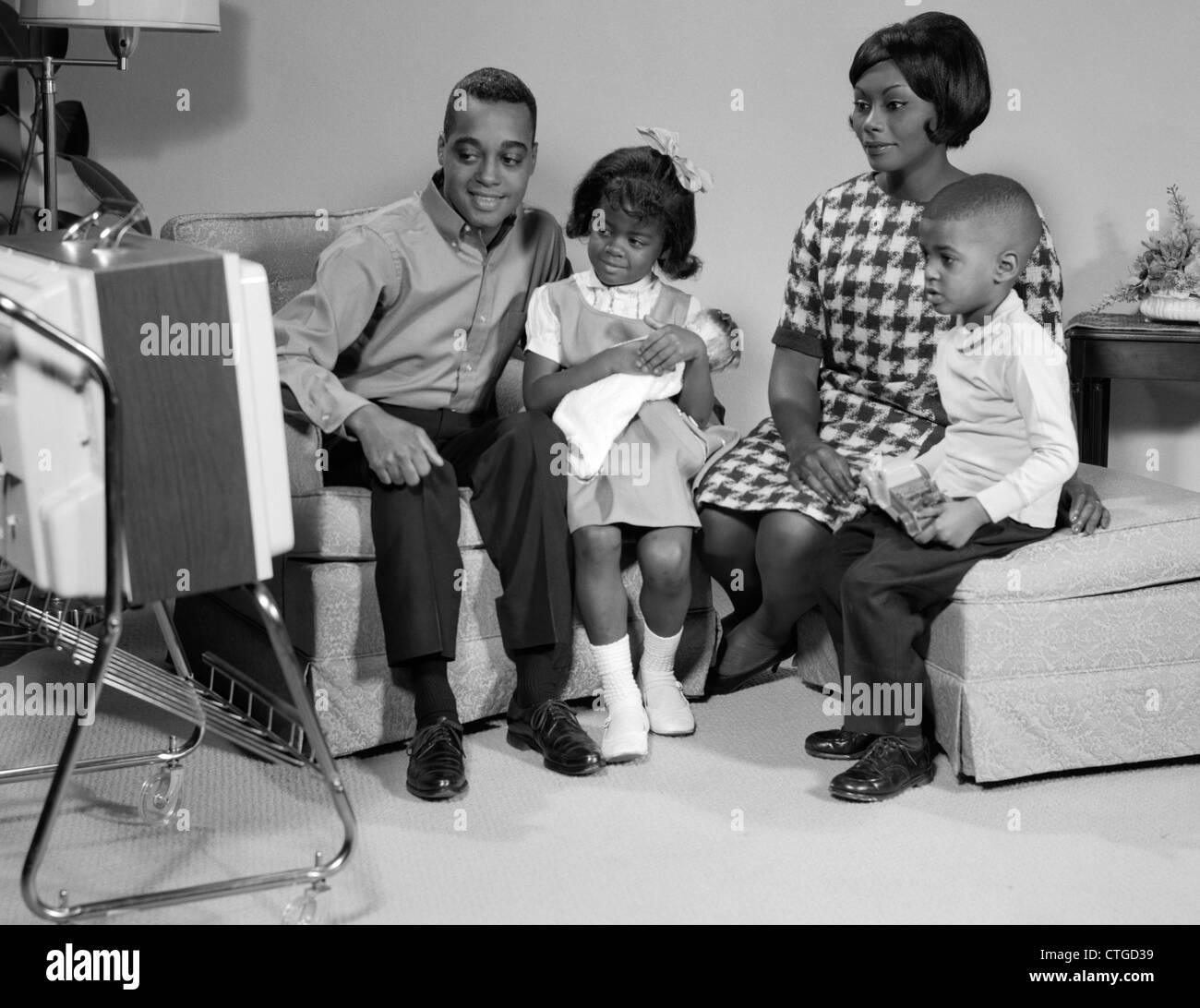 1960s BLACK FAMILY WATCHING PORTABLE TELEVISION Stock Photo