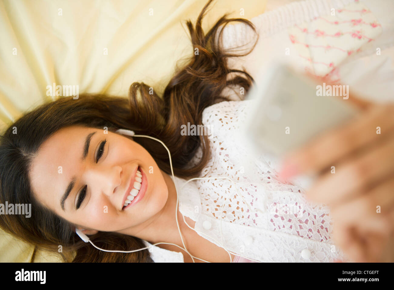 Hispanic woman listening to mp3 player Stock Photo