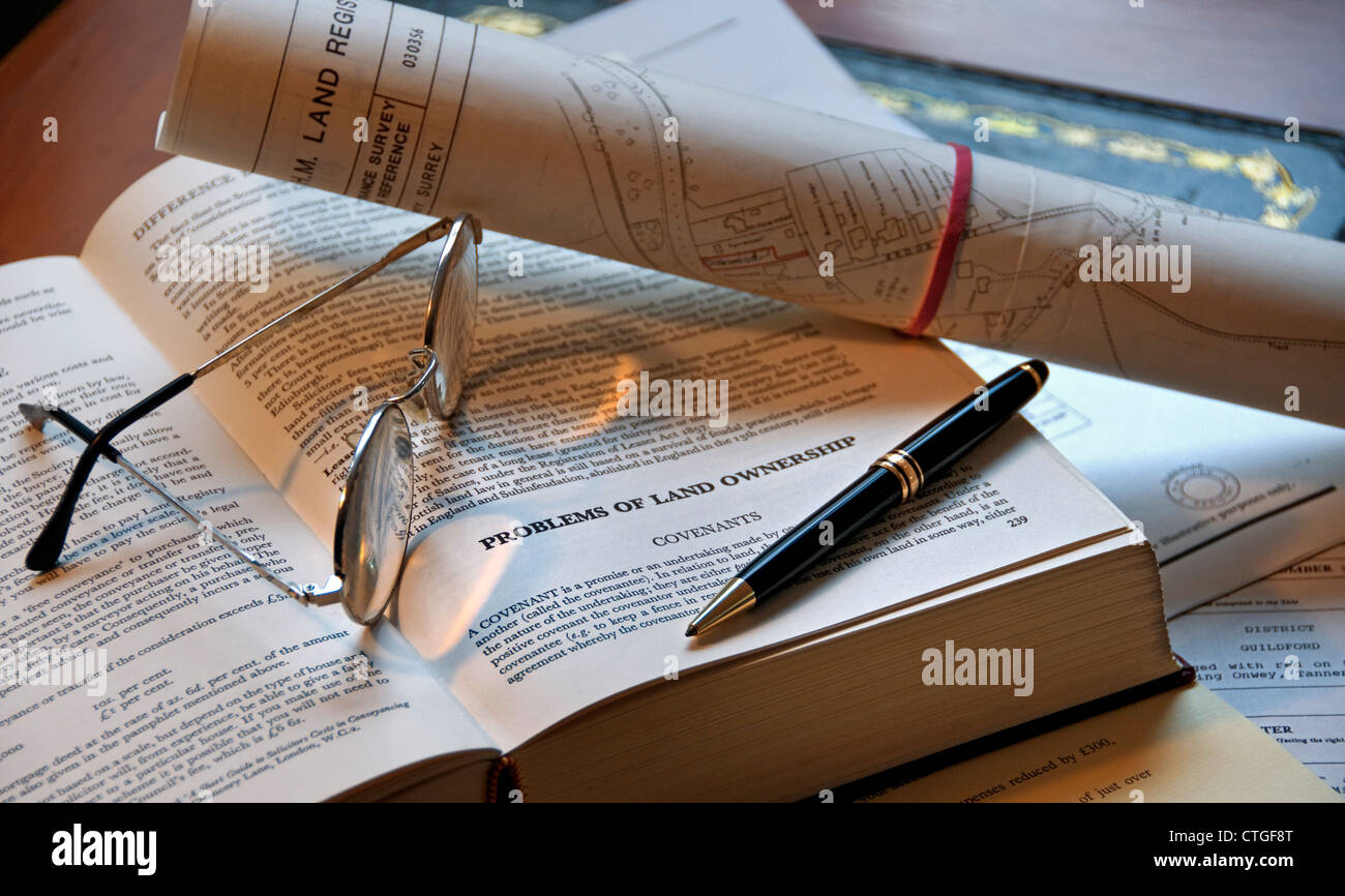 LAND LAWS HOME BUYING LEGAL SEARCHES FEES RIGHTS English property law book, pen, glasses and land registry documents on office desk Stock Photo