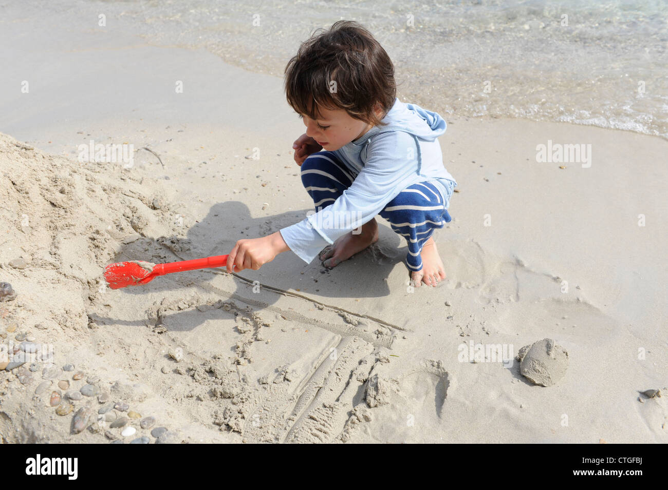 7 YEAR OLD ENGLISH BOY BUILDING A SANDCASTLE ON THE BEACH AT FORMENTOR IN MAJORCA , SPAIN Stock Photo