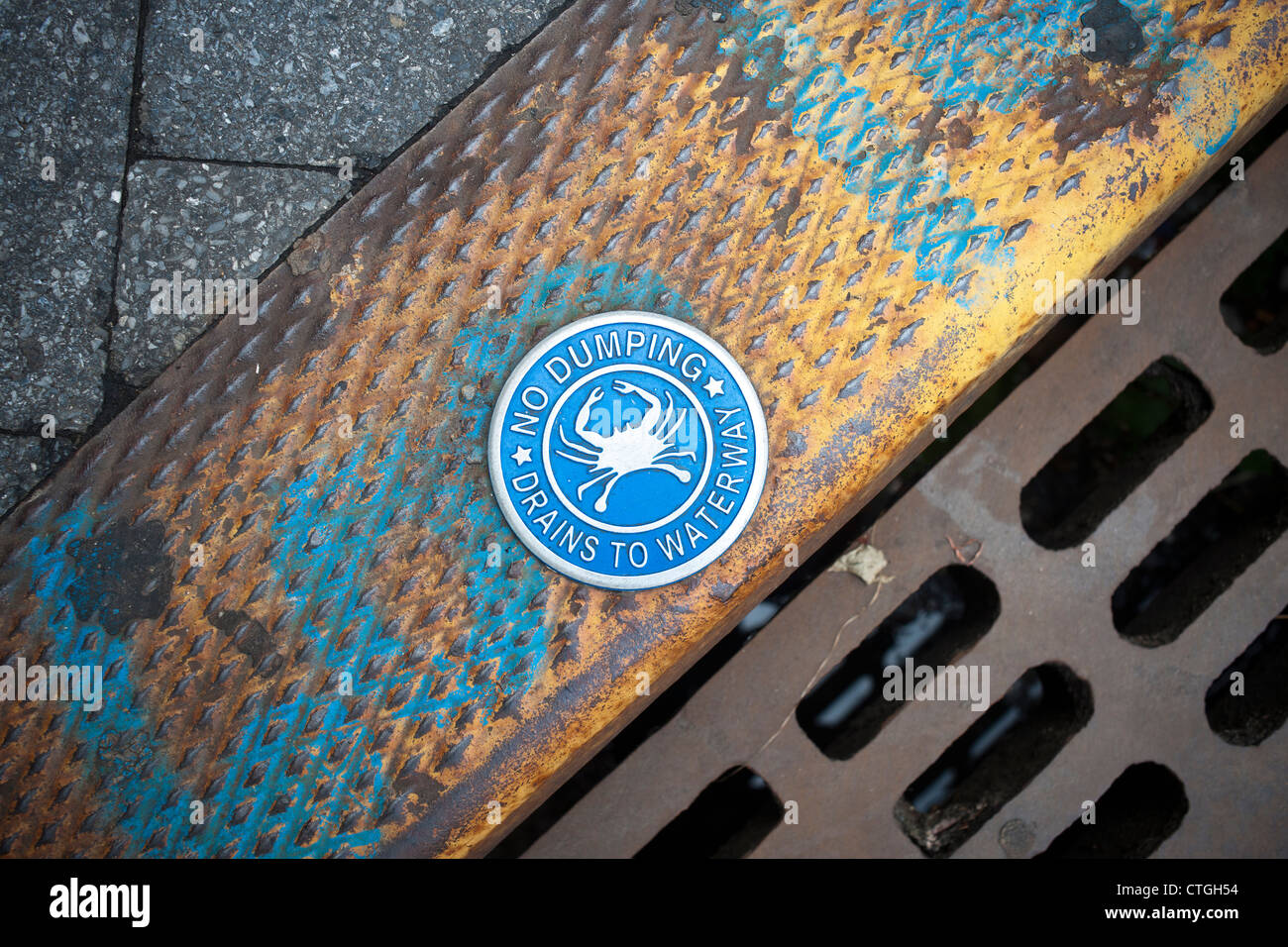 Warning sign on a storm drain in Hoboken, NJ relating to wastewater bypassing treatment and going directly into the waterway. Stock Photo