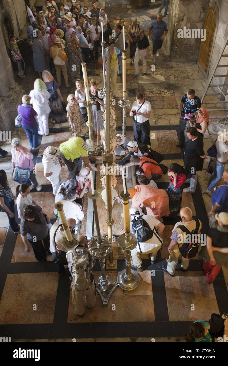 Religious pilgrims and tourists around the Stone of Anointing in the Church of the Holy Sepulchre, Jerusalem, Israel Stock Photo