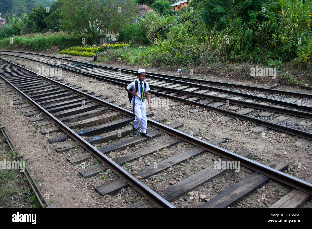 young boy walks along train, rail track in sri lanka Stock Photo