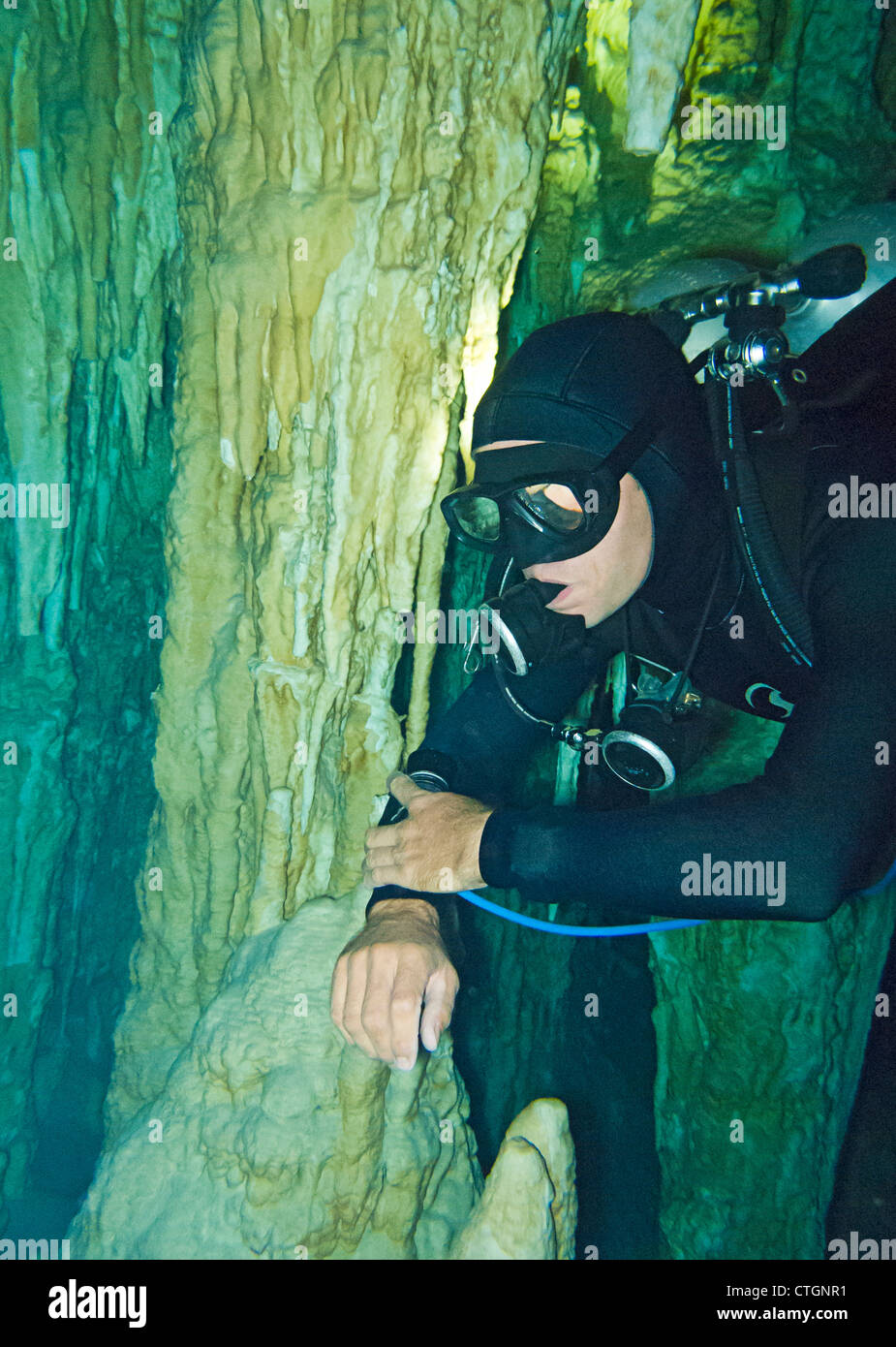 Scuba diver near one of the rock column formations in Dos Ojos, one of many cenotes where people can scuba in Akumal, Mexico Stock Photo