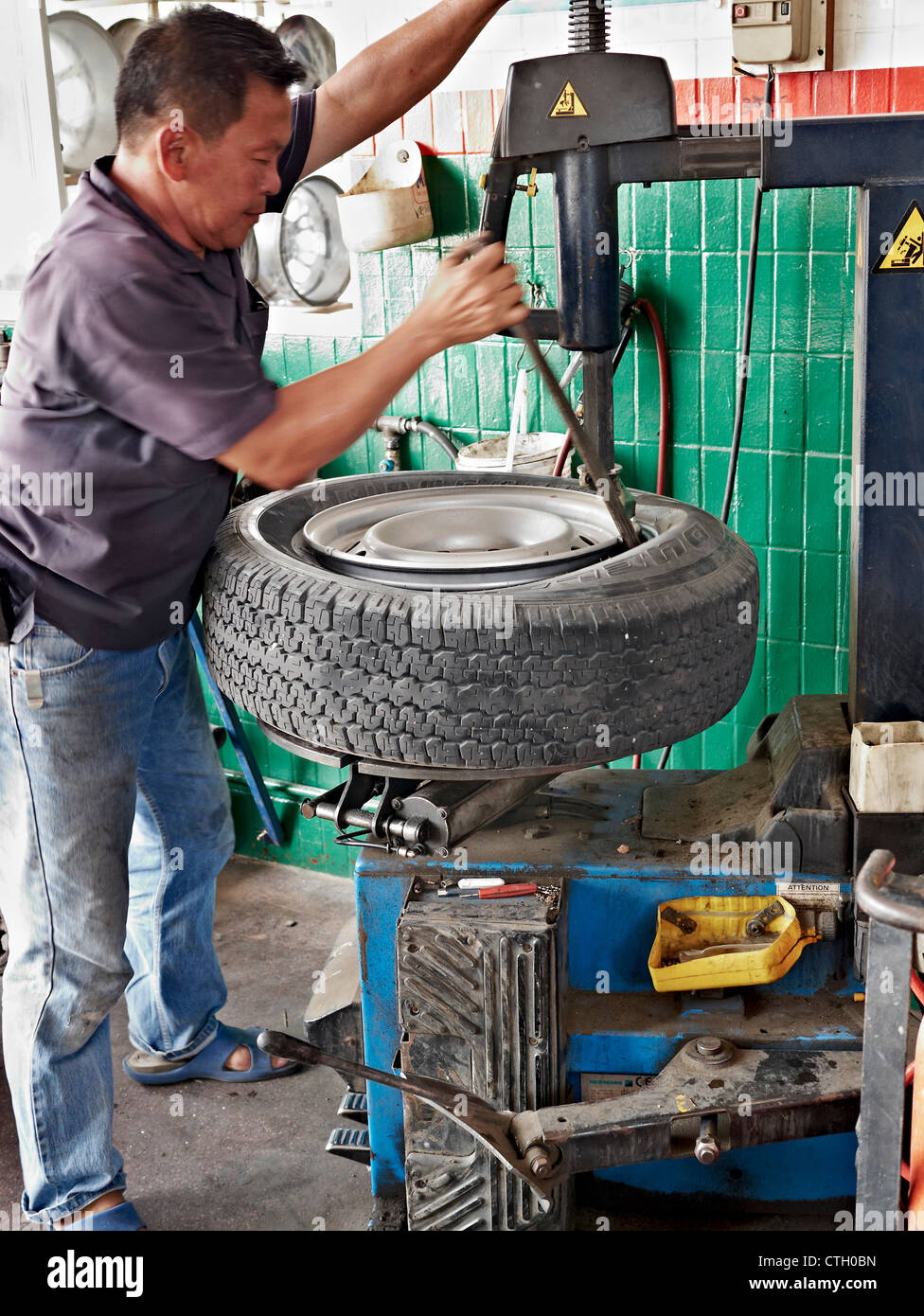 tyre-change-mechanic-using-machinery-and-lever-to-change-a-car-tire