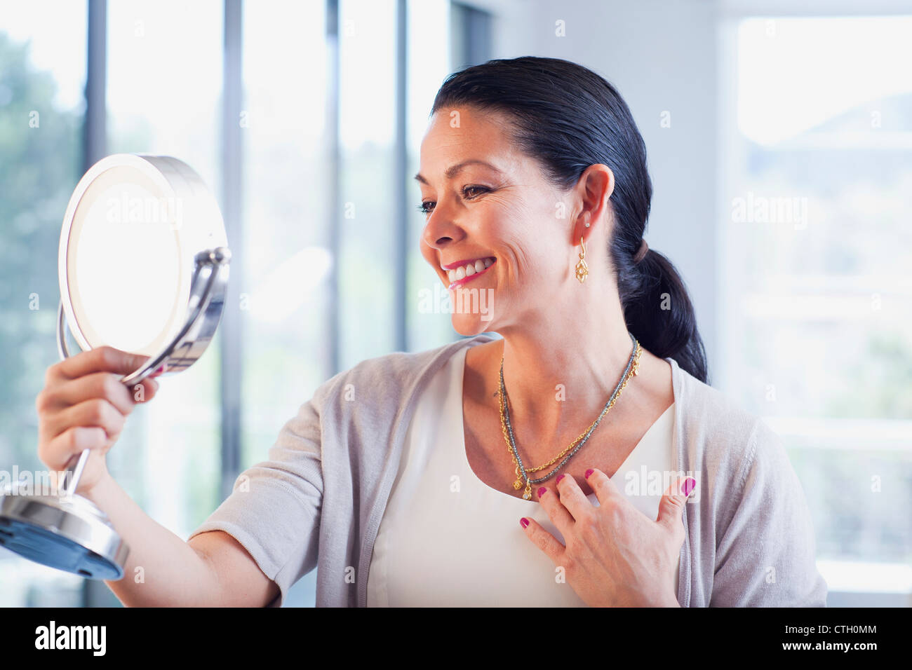 Hispanic woman trying on jewelry in store Stock Photo Alamy